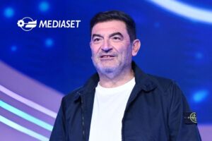 Max Giusti e logo Mediaset