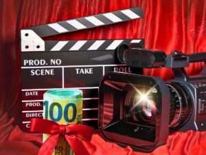 sfondo ciak e videocamera e banconota 100 euro con fiocco