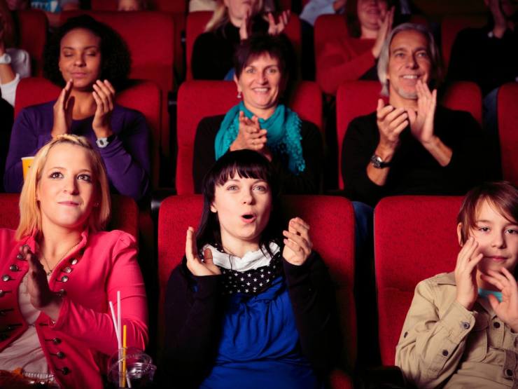 persone sedute nelle poltrone del cinema